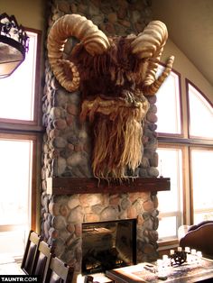 an animal head mounted to the side of a stone fireplace