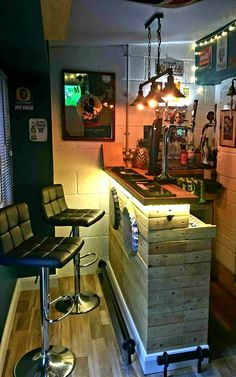 a bar with stools and lights in a small room next to a counter top