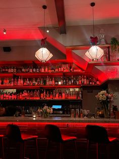 a bar with red lights and lots of bottles