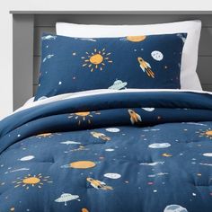 an image of a bed with space themed sheets