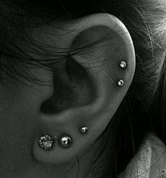 a woman's ear with several piercings on it