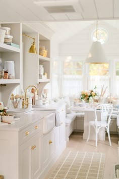 a kitchen filled with lots of white furniture