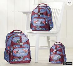 three children's backpacks sitting next to each other on a chair in a room