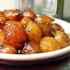 a white bowl filled with fried food on top of a table next to a glass bottle