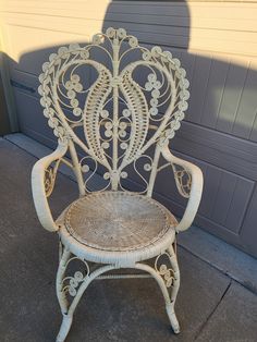 a white wicker chair sitting in front of a garage door