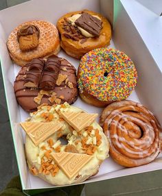 a box filled with lots of different flavored donuts