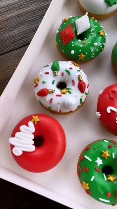 there are many donuts in the box on the table and one is decorated with icing