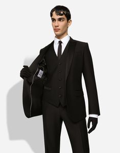 Refined and tailored three-piece wool tuxedo suit with silk satin details. Regular Martini fit Jacket with peak lapels, welt pockets, a breast pocket, and three inner pockets Single-breasted fastening with a double button, lined V-neck vest with five buttons Pants with front slant pockets, rear buttoned welt pockets and satin side bands The jacket measures 73.5 cm - 28.9 inches from the back collar seam on a size IT 48 The crotch measures 17.5 cm - 6.9 inches and the hem is 18 cm - 7.1 inches wide on a size IT 48 The model is 185 cm - 72.8 inches tall and wears a size IT 48 Made in Italy Luxury Fitted Single Breasted Three-piece Suit, Luxury Single-button Sets With Notch Lapel, Luxury Fitted Single-breasted Three-piece Suit, Elegant Three-piece Suit With Concealed Placket For Business, Tailored Black Silk Tuxedo, Tailored Silk Tuxedo With Single Button, Elegant Three-piece Suit With Notch Lapel And Concealed Placket, Silk Notch Lapel Formal Sets, Luxury Fitted Three-piece Suit With Single Button