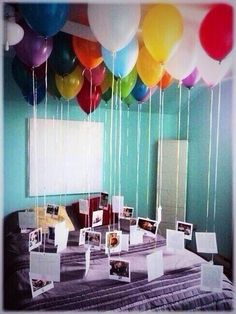 balloons are floating in the air over a table with pictures and photos on it's sides