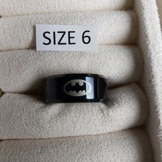 Black Tone Alloy Metal Fashion Band Style Ring. Flat With Beveled Edges. Multiple Batman Logos Engraved On Outside. Size 6. Available In Select Other Sizes. Check Out My Store For More Styles. Please Note: Wider Bands Fit Tighter! Clearing Out Inventory, Make Me An Offer! Willing To Create Great Bundle Discounts! Boutique Item- Has No Manufacturers Tags, But New And Unused. May Still Have Size Tag Attached In Some Instances. Smoke And Pet Free Home. Batman Logos, Batman Ring, Black Batman, Engraved Ring, Batman Logo, Metal Fashion, Wide Bands, Engraved Rings, Womens Jewelry Rings