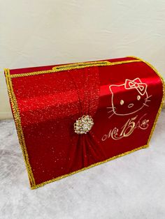 a red box with a hello kitty design on the front and gold trimmings