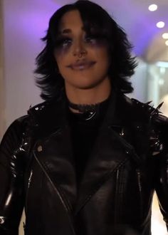 a woman with black hair wearing a leather jacket