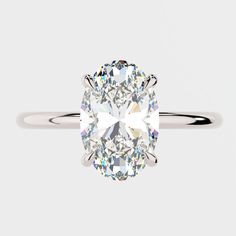 an oval cut diamond ring on a white background