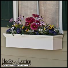 a wooden window box with flowers in it