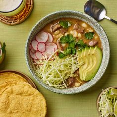 a bowl of soup with beans, avocado, radishes and other vegetables