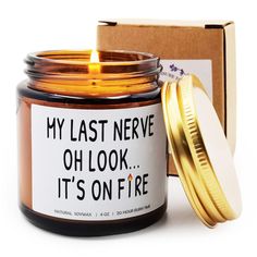 a candle that is sitting in front of a box with a label on it saying, my last nerve oh look it's on fire