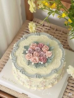 a decorated cake sitting on top of a table next to a vase filled with flowers