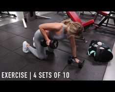 a woman squatting on the ground with dumbbells in front of her and another bag behind her