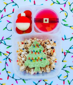 a plastic container filled with christmas treats on top of a table