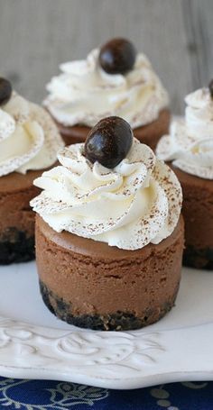 there are several desserts on the plate with white frosting and chocolate toppings