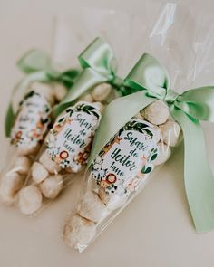 three bags of white chocolates wrapped in green ribbon