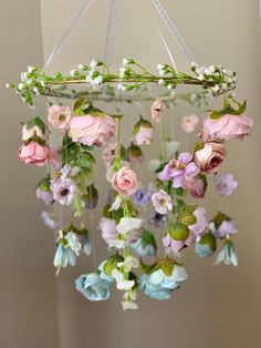 an arrangement of pink and blue flowers hanging from a chandelier