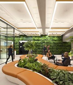 an office with plants growing on the wall and people sitting at tables in the background