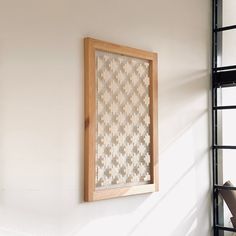 a wooden frame hanging on the wall next to a window