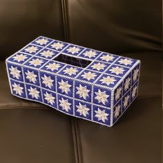 a blue and white box sitting on top of a leather couch