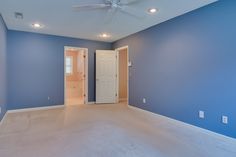 empty room with blue walls and ceiling fan