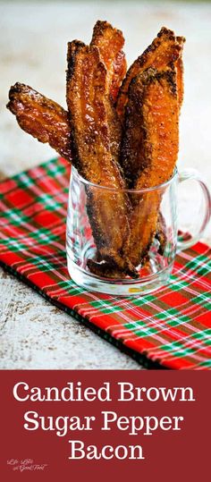 candied brown sugar pepper bacon in a glass cup on a red and green tablecloth