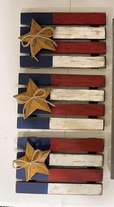 three wooden american flags with bows tied to them