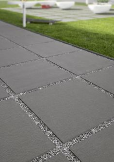 an outdoor walkway with grass and concrete blocks