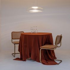 a table with two chairs and a wine glass on it