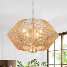 a large bamboo chandelier hanging over a dining room table with flowers on it