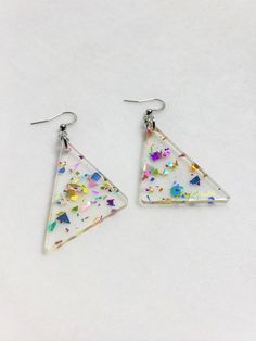 Choice of sterling silver .925 or surgical stainless steelApproximately 1.25" wide, and 2.5" long from top of metal hookInspiration straight from the 80s\90s, redesigned for the new retro look. These earrings are sure to sparkle, and packed full of rainbow fun! Made with a clear acrylic, and rainbow glitter that will differ in each earring, making them unique to you!This product is made to order, colors may appear slightly differentCare: the metal and acrylic can be cleaned with waterEach order Silver Triangle Earrings For Party, Silver Triangle Party Earrings, Triangle Silver Jewelry For Party, Rainbow Confetti, Retro Earrings, Earring Making, Retro Rainbow, Rainbow Glitter, New Retro