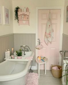 a white bath tub sitting next to a pink door