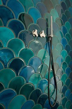 the shower head is attached to the mosaic tile wall