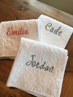 three personalized towels on a wooden table