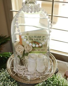 a baby shower gift set under a glass dome