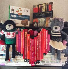 two stuffed animals are sitting on top of books