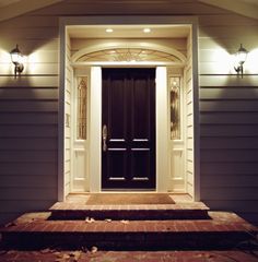 the front door of a house with two lights on