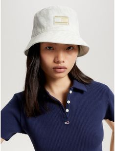 Tommy Hilfiger women's hat. Top off your look with a little throwback styling courtesy of our bucket featuring an allover Tommy Jeans logo print. Part of our Tommy Jeans collection.  Material: 100% Better Cotton Initiative. Beige Bucket Hat With Visor, Trendy Spring Visor Bucket Hat, Retro Cotton Hat, Cream Bucket Hat With Flat Brim, Spring Hats With Curved Visor, Tommy Hilfiger Store, Block Logo, Jeans Collection, Jeans Logo