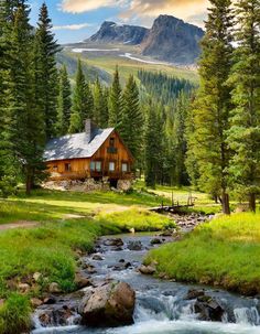 a cabin in the mountains with a stream running through it and trees around it,