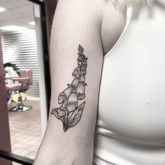 a black and white photo of a flower tattoo on the left arm, which is in front of a woman's right arm