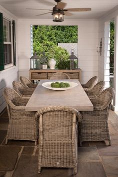 a dining room table with chairs and a bowl of food on it's centerpiece