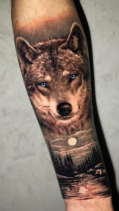 a man's arm with a wolf on it and the moon in the sky