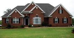 a red brick house with white trim and black shutters