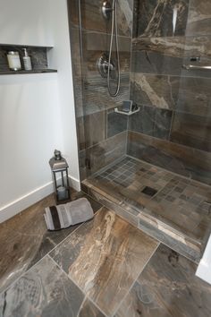 a bathroom with gray tile and wood flooring