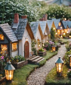 miniature houses are lit up in the garden